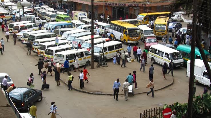 Dozens of white and yellow matatus parked closely together at a busy Kenyan transport terminal during a period of fuel supply disruption.