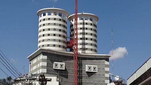 A high-angle view of the Nation Centre building in Nairobi, featuring its iconic twin-tower architectural design against a clear sky.