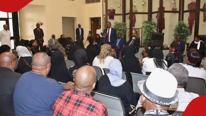 A formal government meeting in Saudi Arabia where officials and representatives are seated in a hall discussing labor policy updates and nationalization.