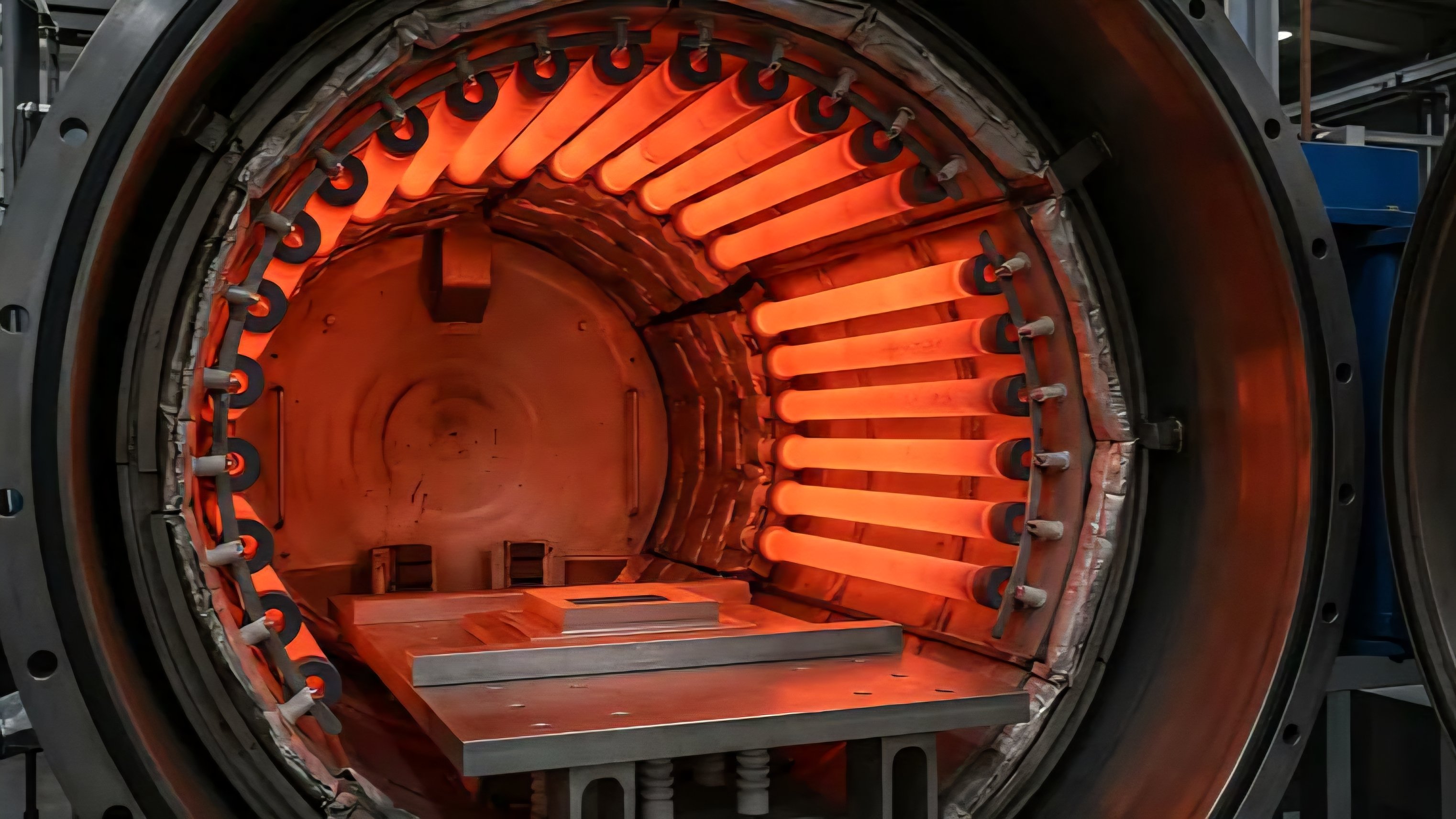 Interior view of a cylindrical vacuum furnace featuring heating elements and internal support structure for thermal processing.