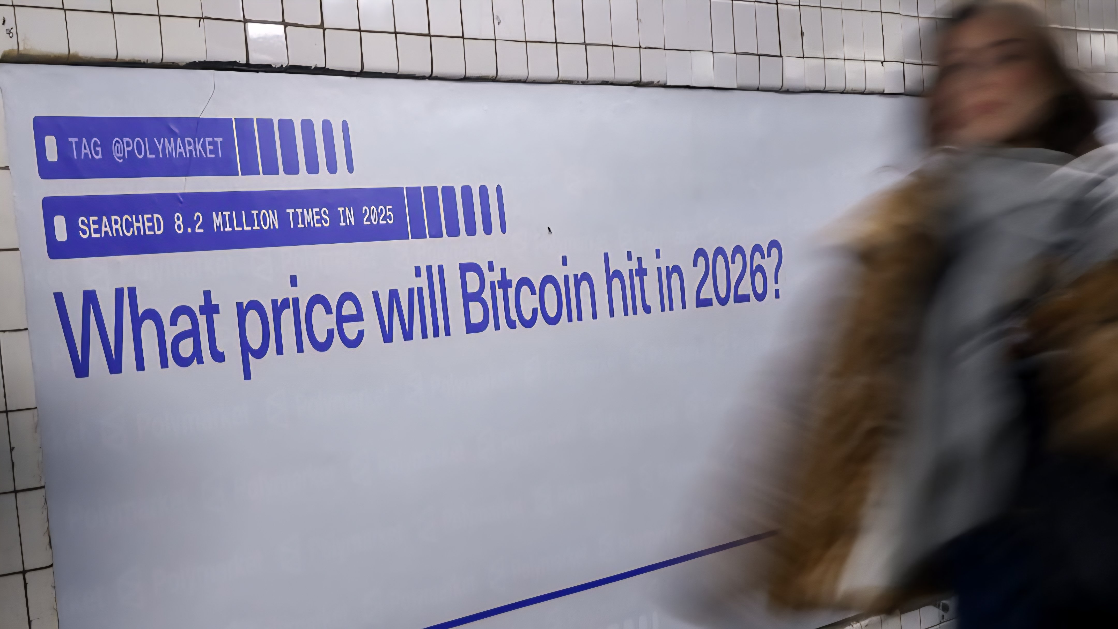 A blurred motion shot of a person walking past a large advertisement in a subway station asking about the price of Bitcoin in 2026.