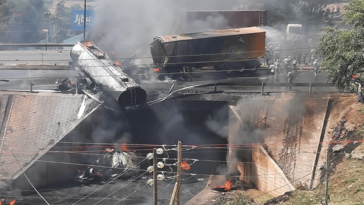 View of the Southern Bypass overpass near Shree Swaminarayan Academy with emergency vehicles and the charred remains of a fuel tanker on the road below.