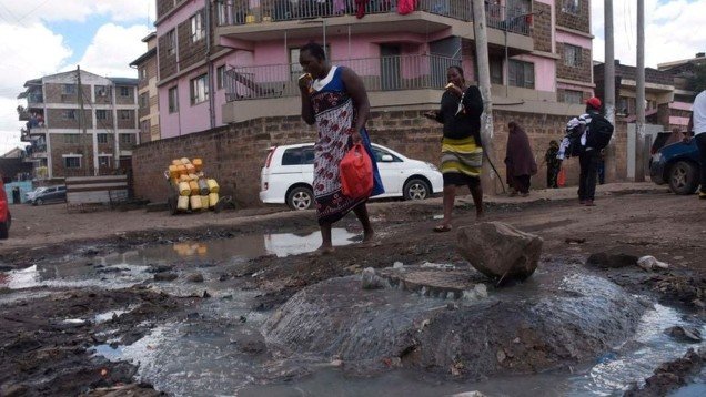 Resident jumping over a sewer line in Eastleigh, Nairobi, highlighting public access and local infrastructure.