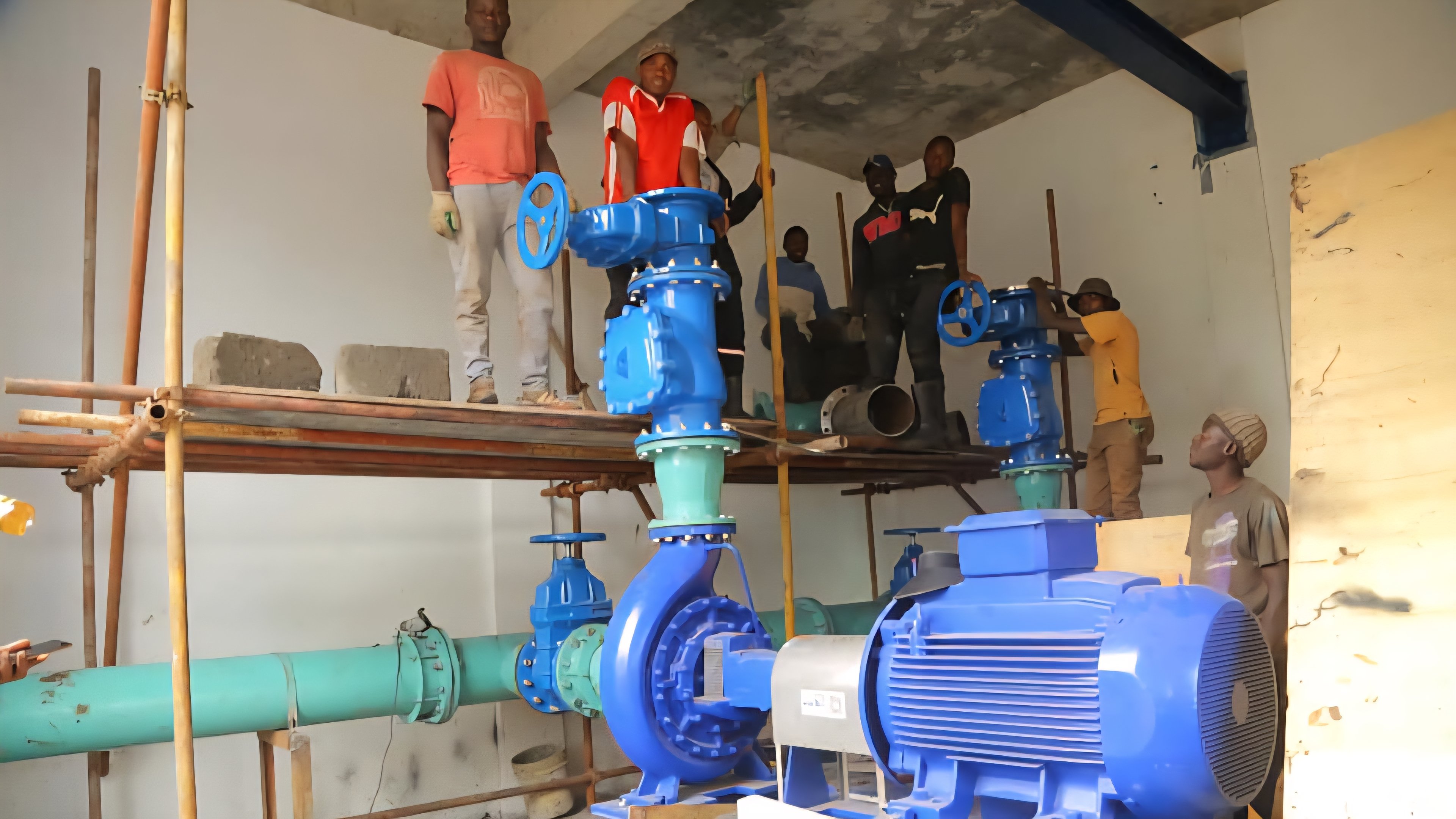 A technician inspecting a large industrial water valve and pipe network at a treatment plant.