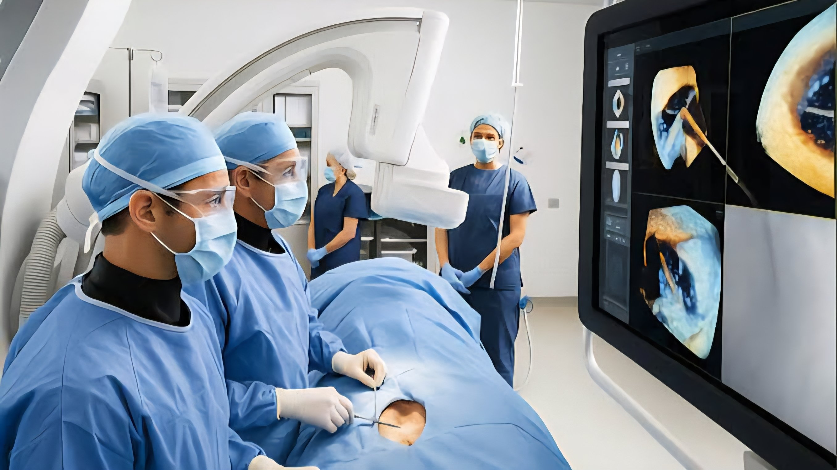 Two surgeons in blue scrubs and face masks perform a laparoscopic procedure in a high-tech operating room equipped with digital monitoring screens.