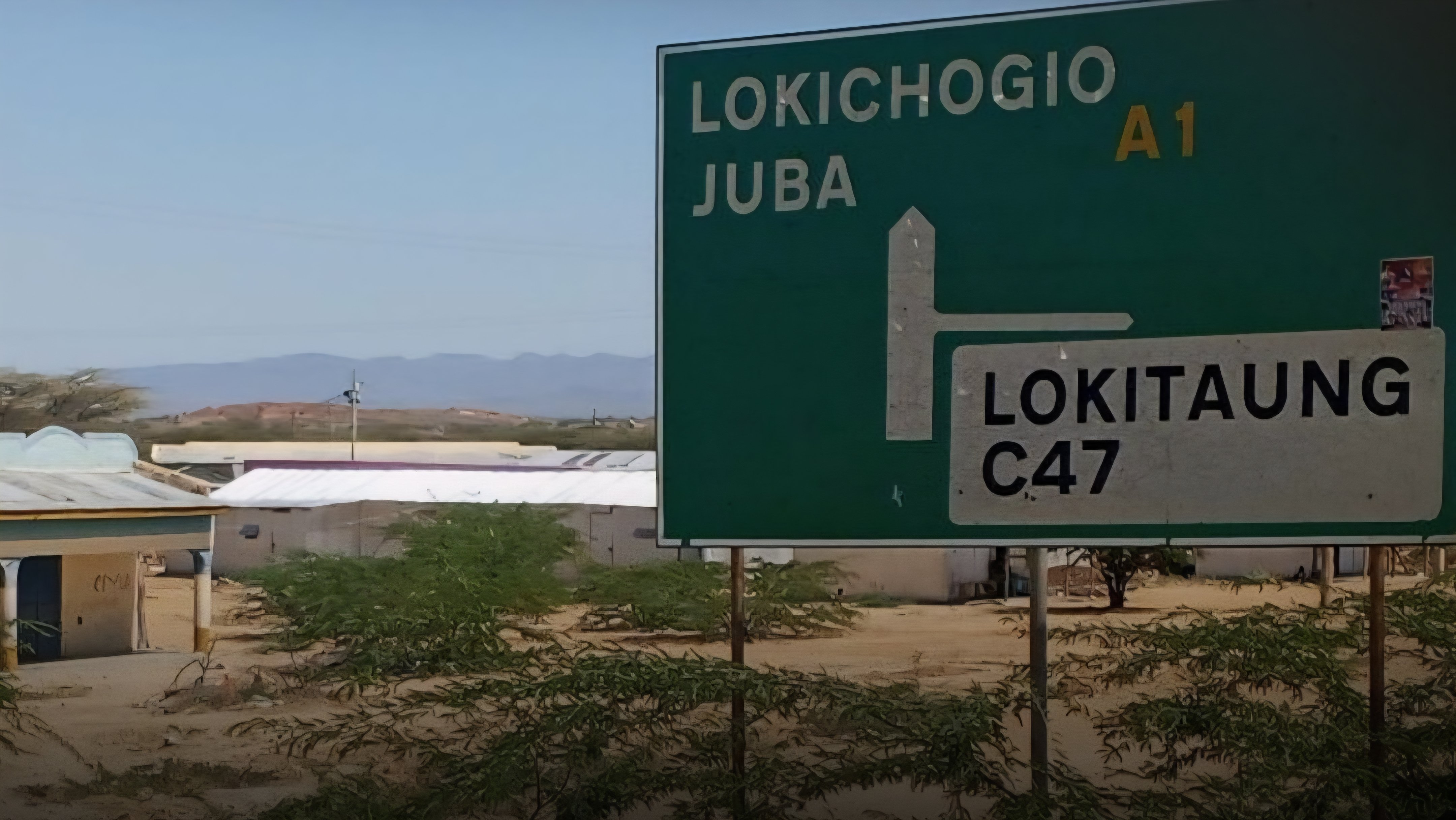 A large green directional road sign at a road junction in Turkana County indicating routes to Lokichogio, Juba along the A1 highway and Lokitaung along the C47 road.