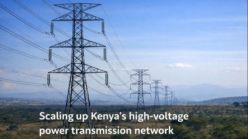 Series of high-voltage power transmission towers extending across open Kenyan landscape with text overlay on scaling up the network.