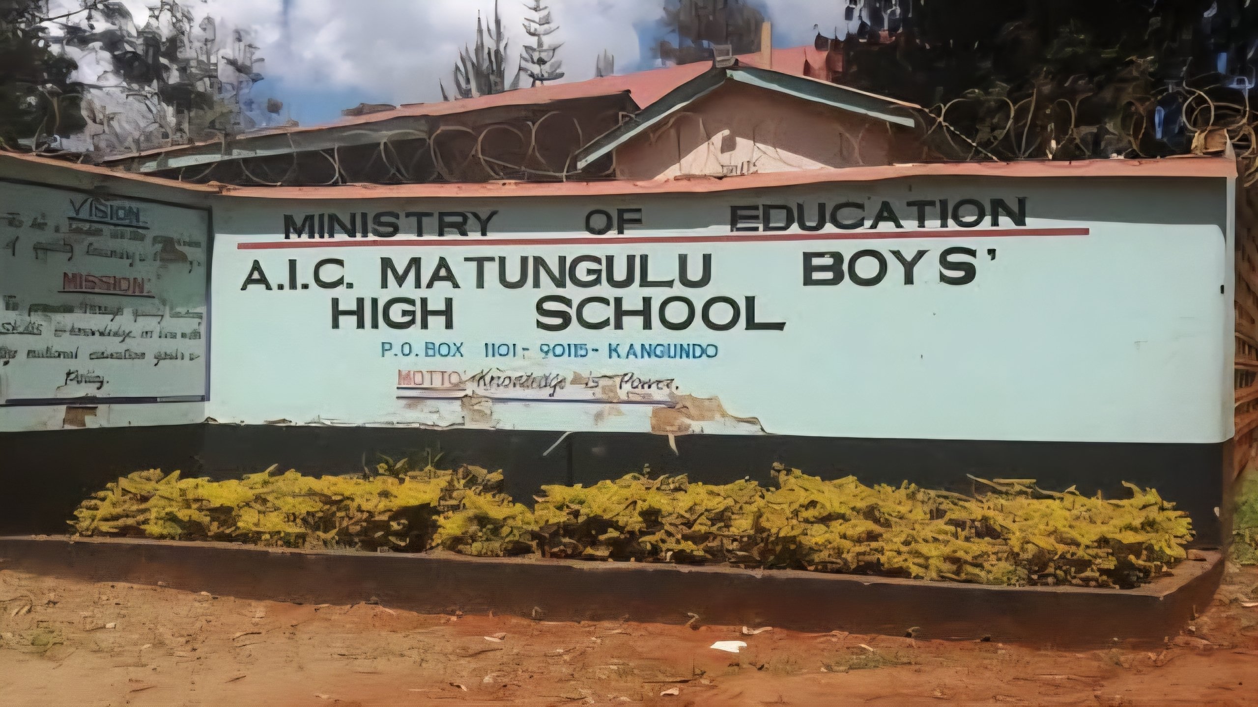 Internal view of a burnt-out dormitory at Matungulu Boys High School showing charred metal bed frames and debris.