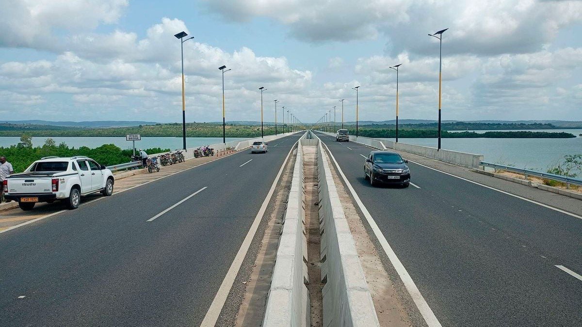 Mwache Bridge, a key part of the Dongo Kundu Bypass, with coastal scenery and trucks.
