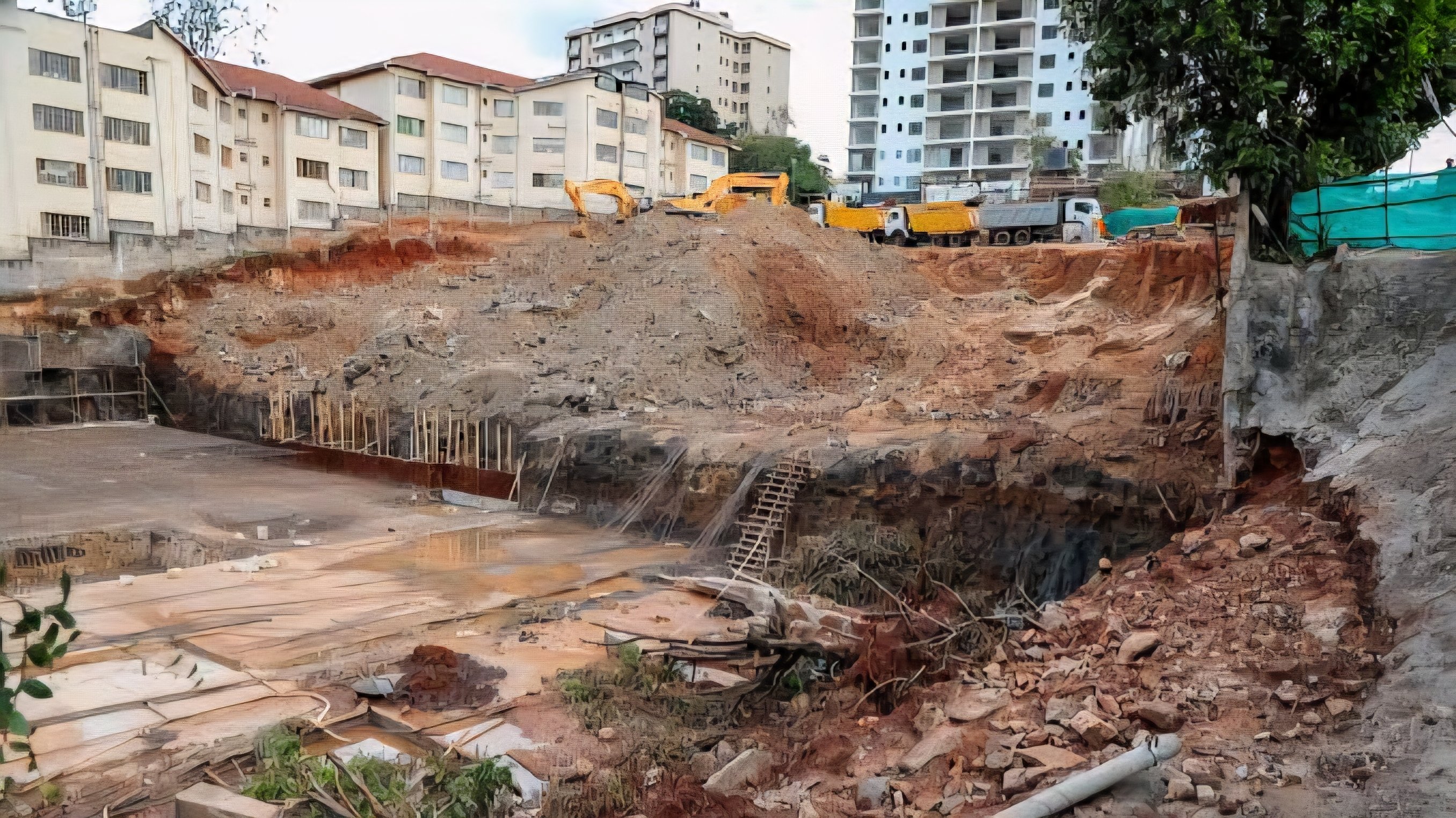 An excavation site for a multi-storey mixed-use apartment building showing earth-moving equipment and surrounding residential buildings in Parklands, Nairobi.