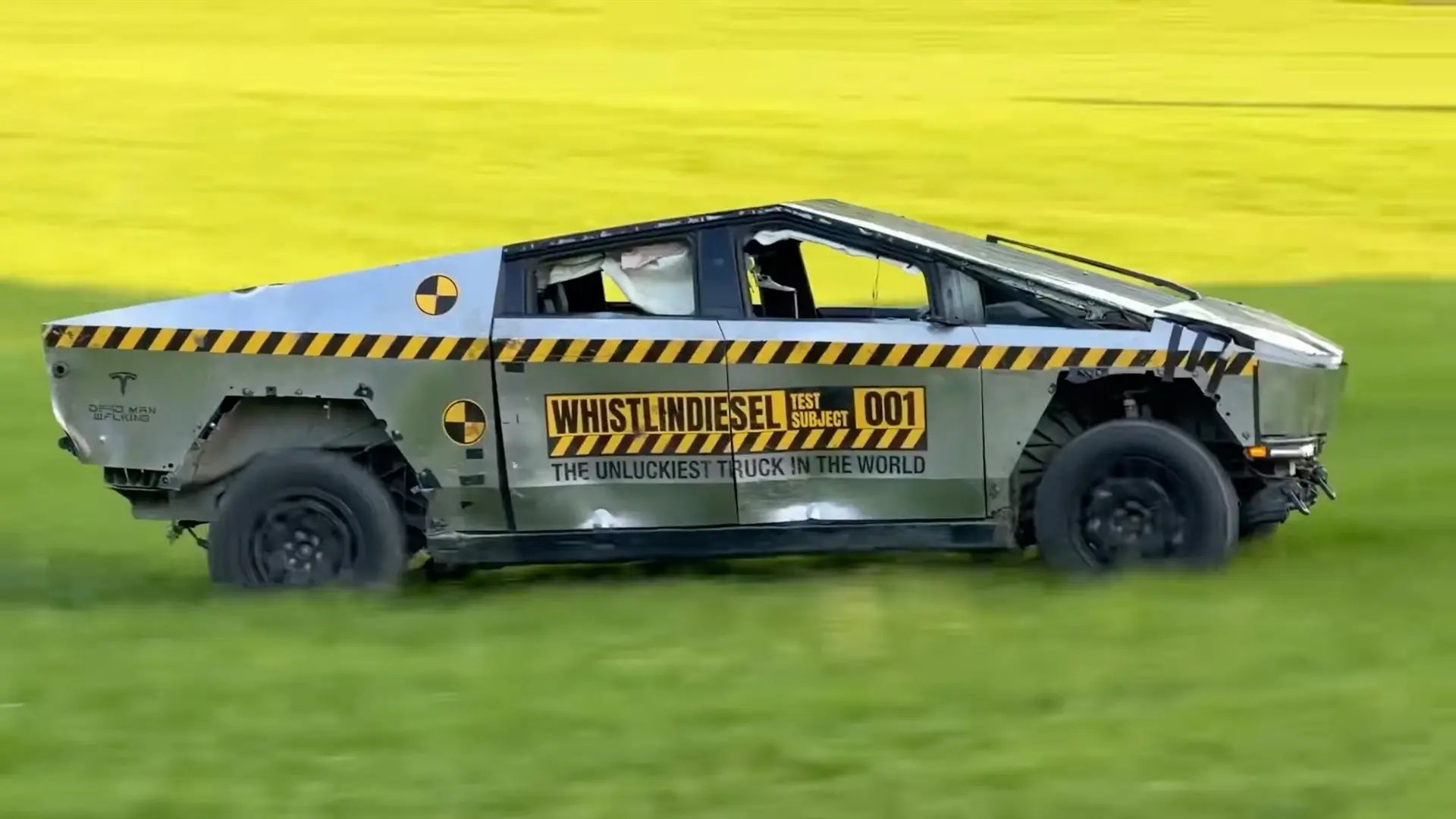 A custom modified Tesla Cybertruck with WhistlinDiesel decals driving across a field.