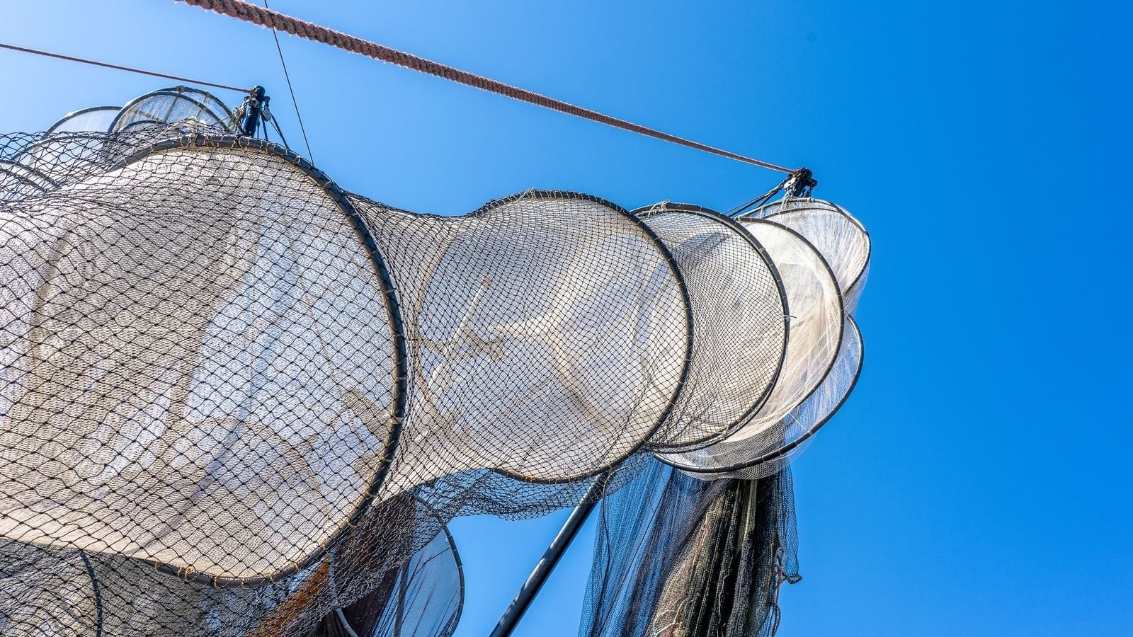 A Chinese rocket booster recovery vessel equipped with a specialized cable catching net structure at sea off Hainan Island.