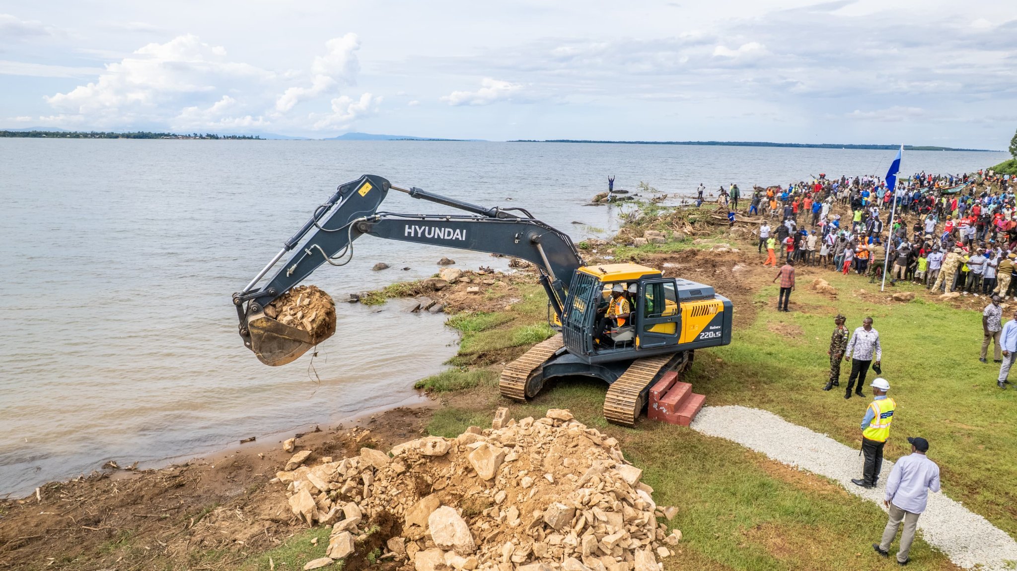 Construction workers and heavy machinery at the shoreline of Lake Victoria during the groundbreaking ceremony for the Usenge Pier project in Siaya County.