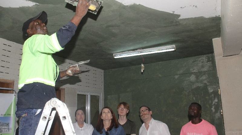 A trainer demonstrating the application of Mixx Cement coating on a wall surface during a product launch session in Nairobi, Kenya, May 2026.