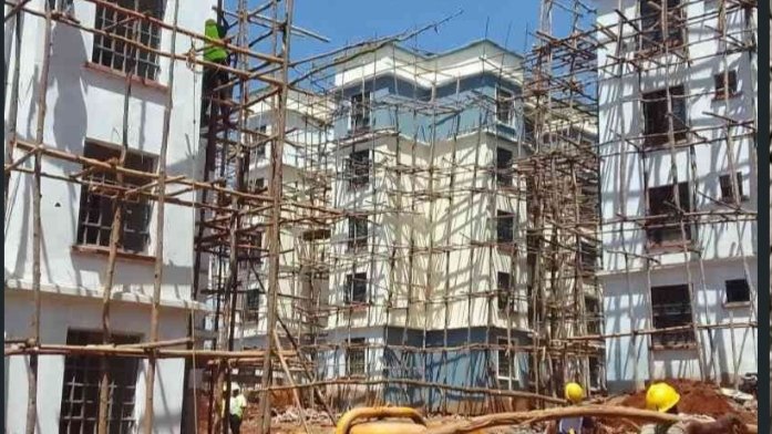 Construction workers on wooden scaffolding at a multi-story affordable housing building site in Kenya