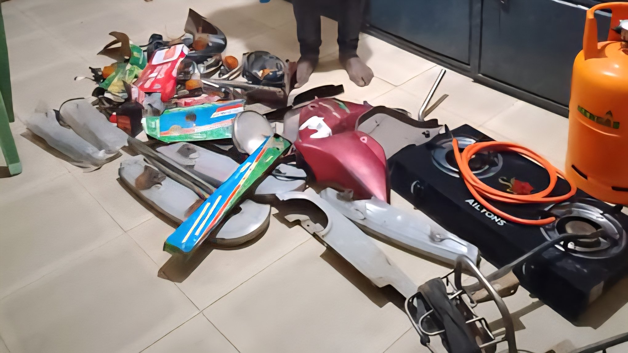 A row of recovered mobile phones and a gas cylinder placed on a wooden table at a police station as evidence