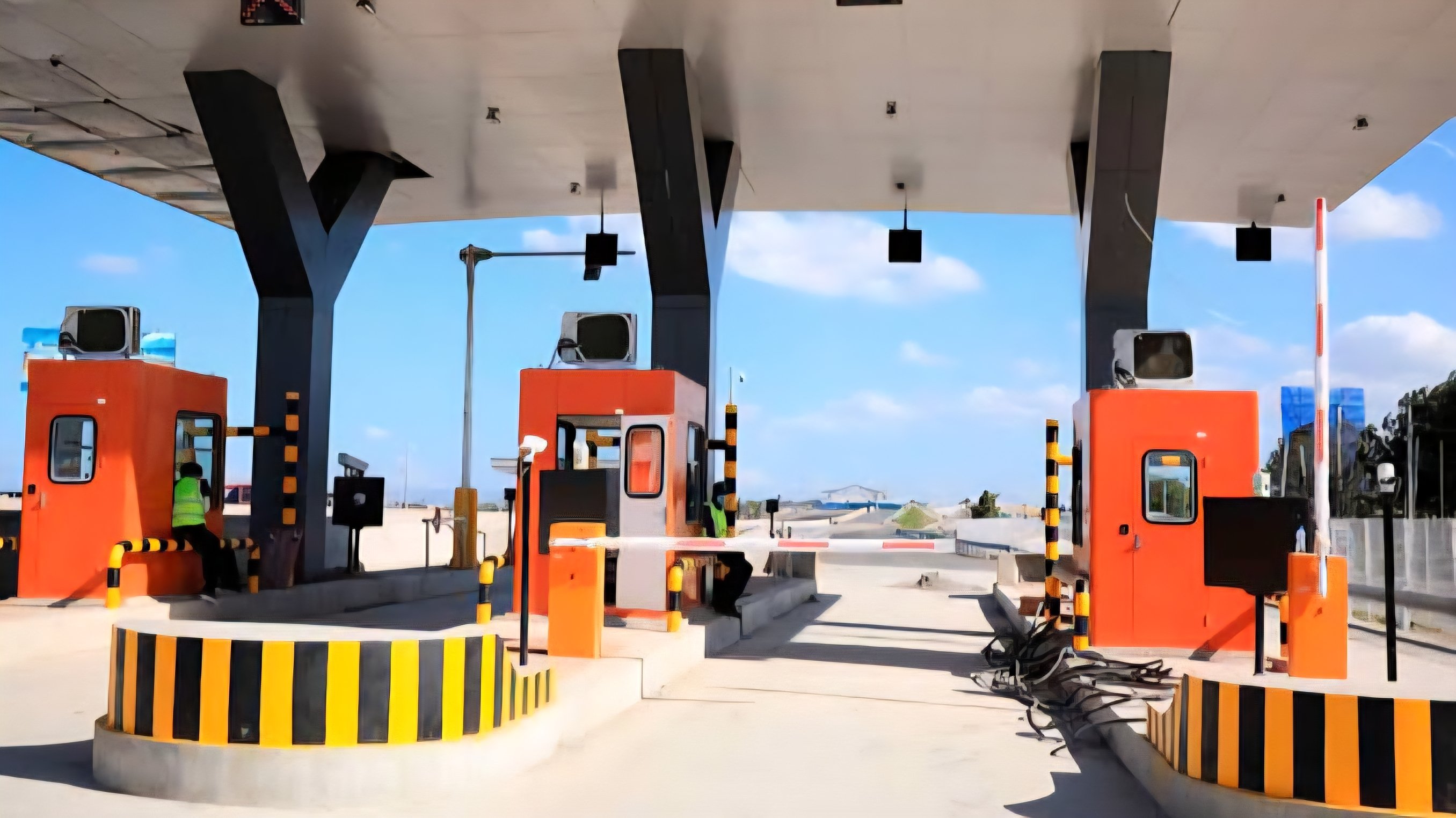 A toll station on a modern multi-lane highway in Kenya with cars passing through collection booths.