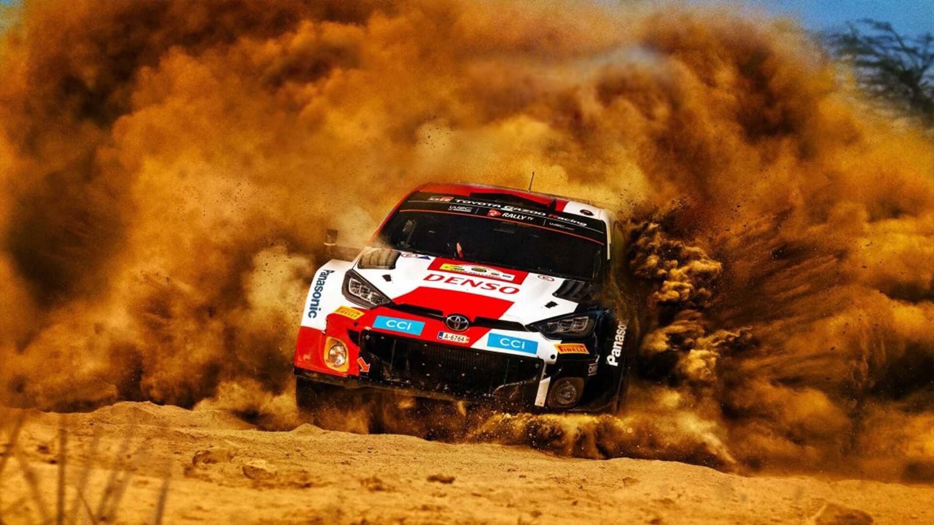 A high-speed rally car kicks up thick dust while navigating a rocky corner in the Kedong stage of the Safari Rally in Naivasha.