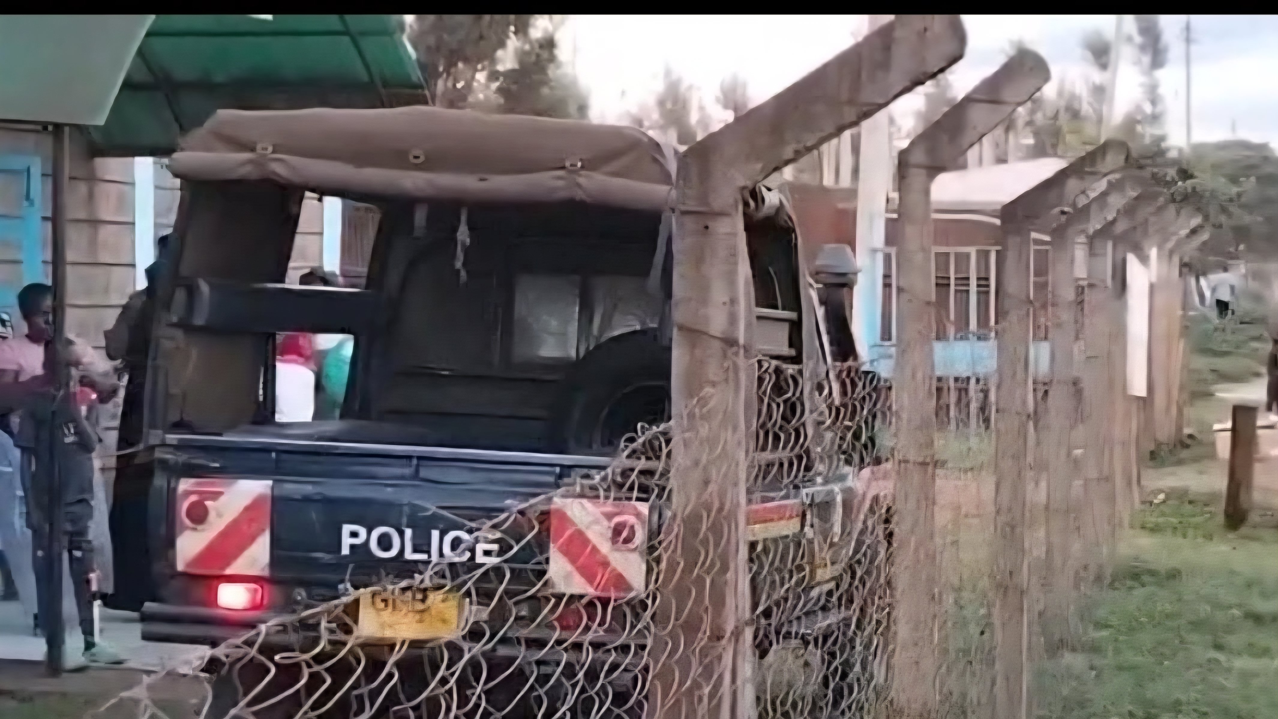 A Kenyan police vehicle parked outside a fenced facility in Kirinyaga County following a reported drowning incident.
