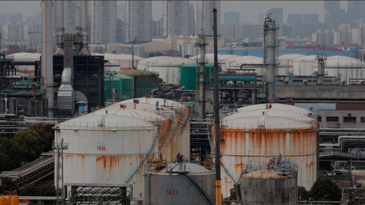Large white cylindrical crude oil storage tanks at a Sinopec plant in Shanghai, China.
