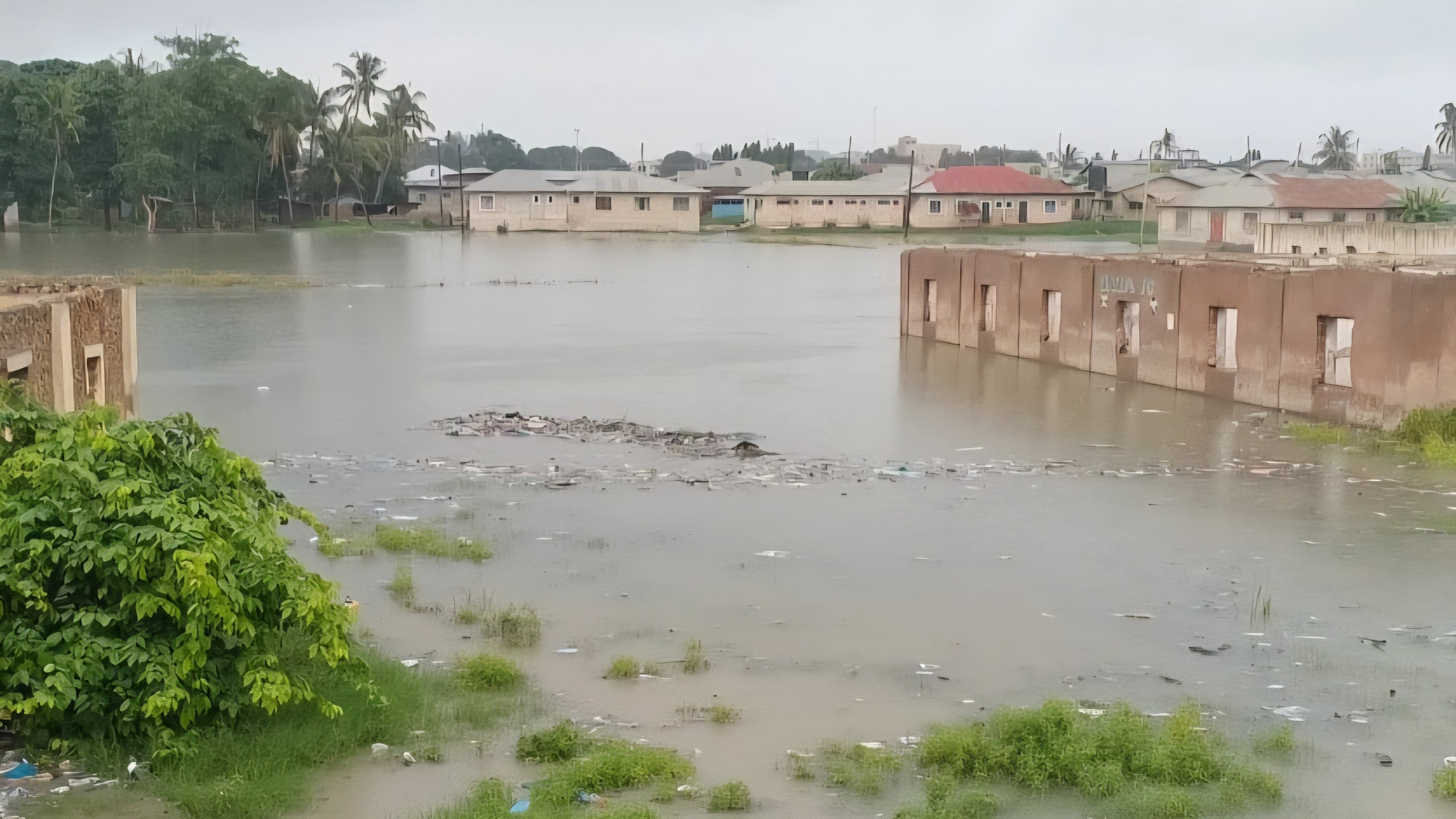 Floodwaters submerge residential buildings and surrounding vegetation in a coastal Kenyan settlement following heavy rainfall.