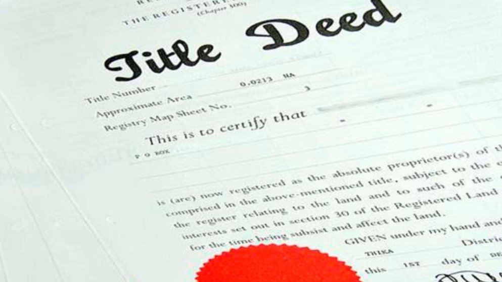 A close-up view of an official Kenyan title deed document featuring a red seal and registry details.