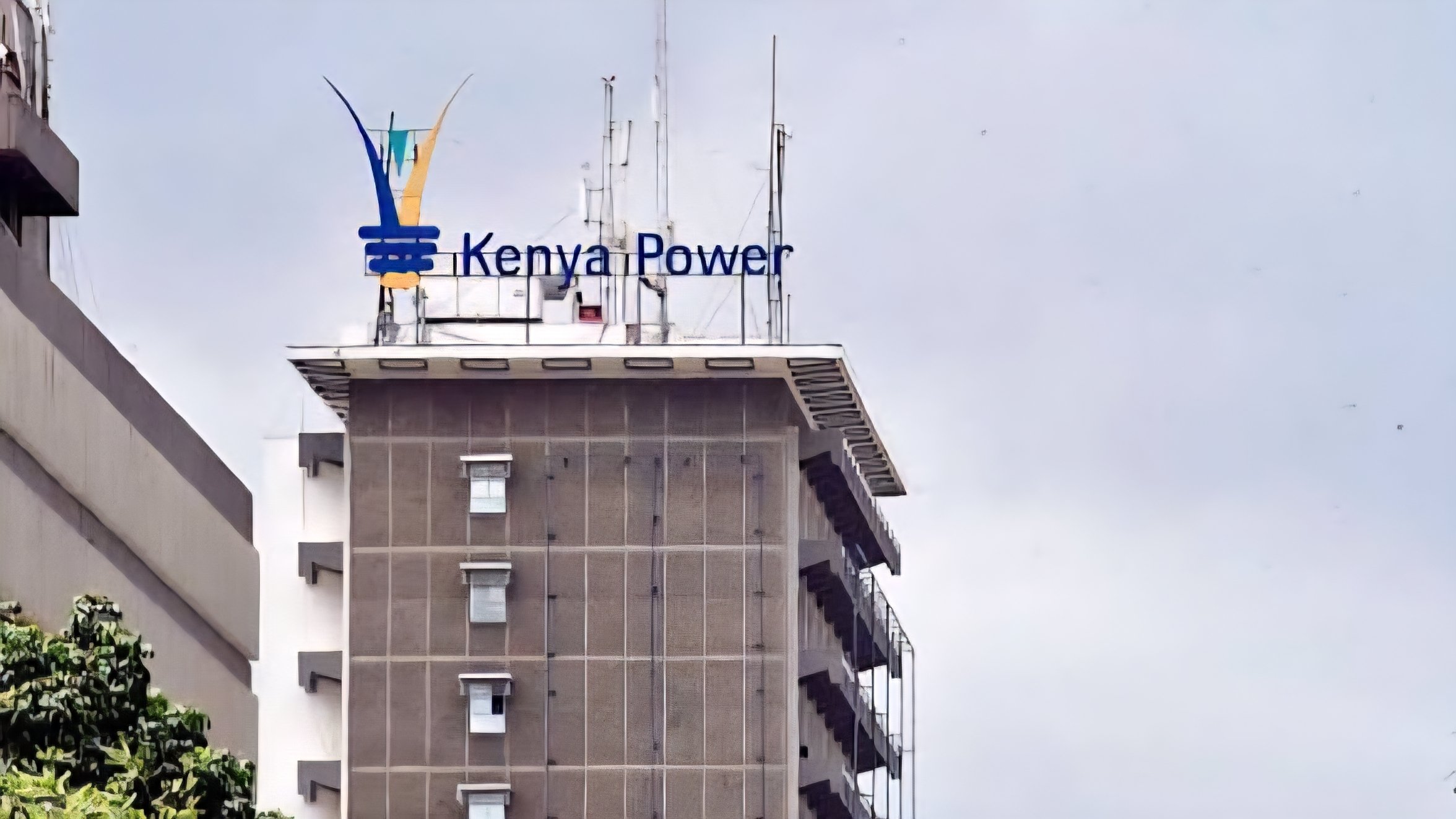 Exterior view of the Kenya Power and Lighting Company headquarters at Electricity House in Nairobi, showing the company logo on the rooftop