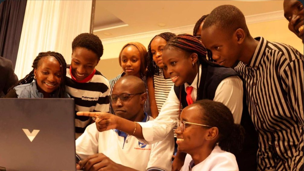 Text Students gathered around a computer screen during a live radio transmission event in Nairobi.