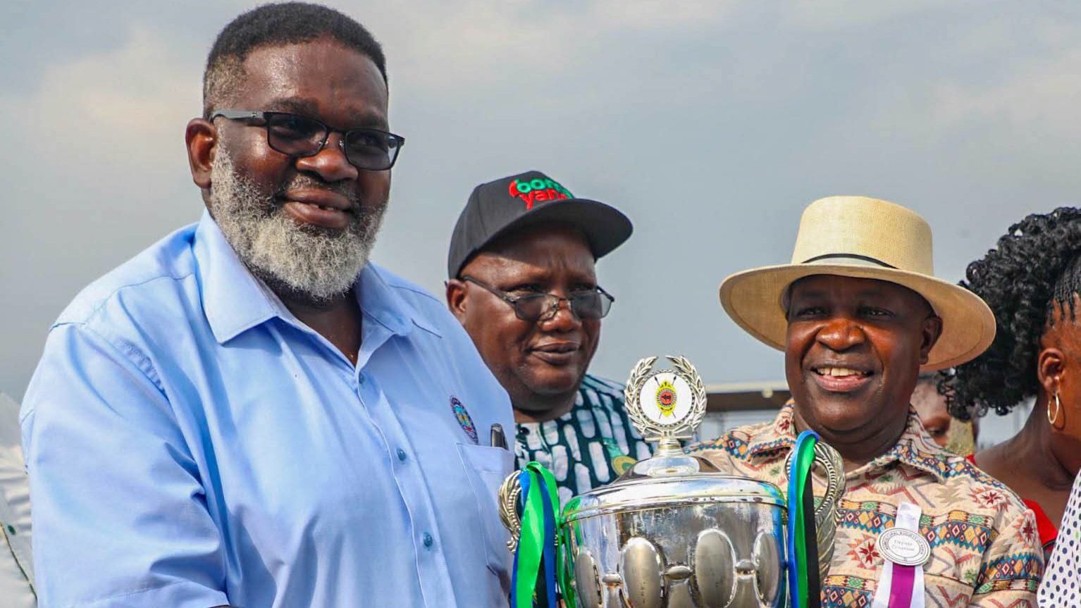 Kisumu Deputy Governor Dr Mathew Ochieng Owili presents a trophy to Kenya Ports Authority officials at Mamboleo Showground.
