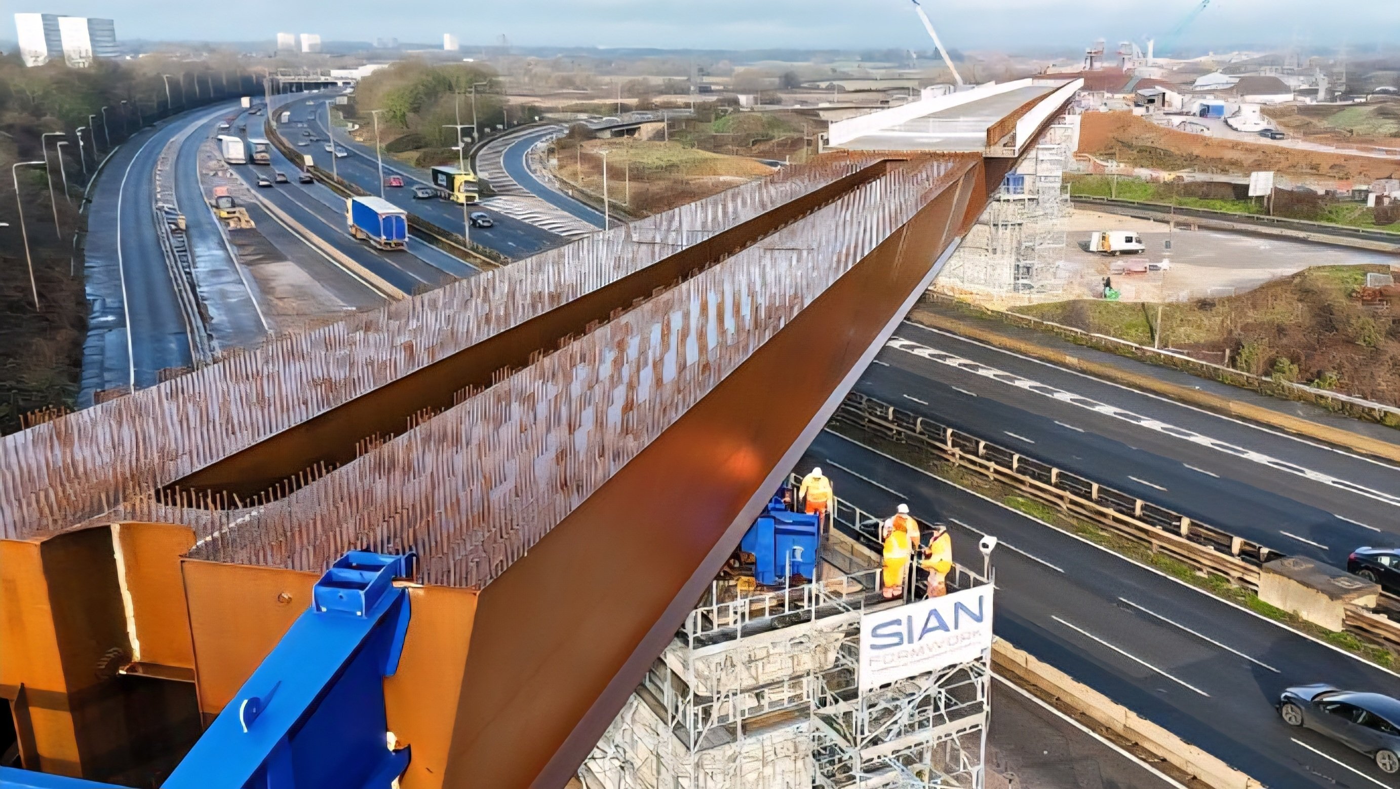 Aerial view of the HS2 construction site showing the massive 4,600-tonne viaduct being precisely slid into position above a live motorway, highlighting the scale, complexity, and precision of the landmark engineering operation.