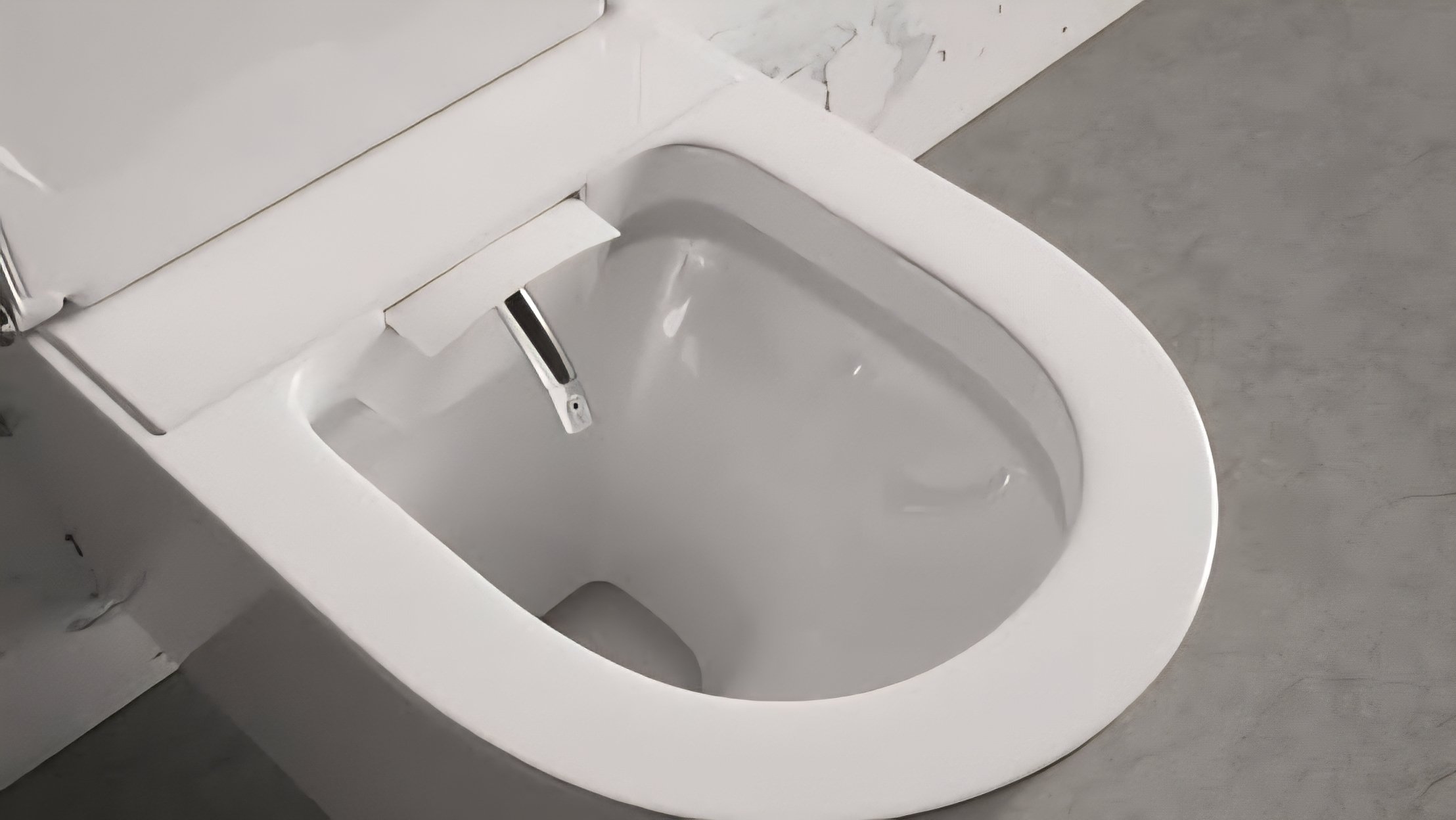 A close-up view of an integrated toilet bidet nozzle spraying a clean stream of water inside a modern white ceramic toilet bowl.