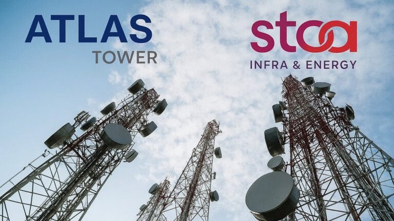 Tall lattice telecommunications towers standing against a clear blue sky in a rural Kenyan landscape.