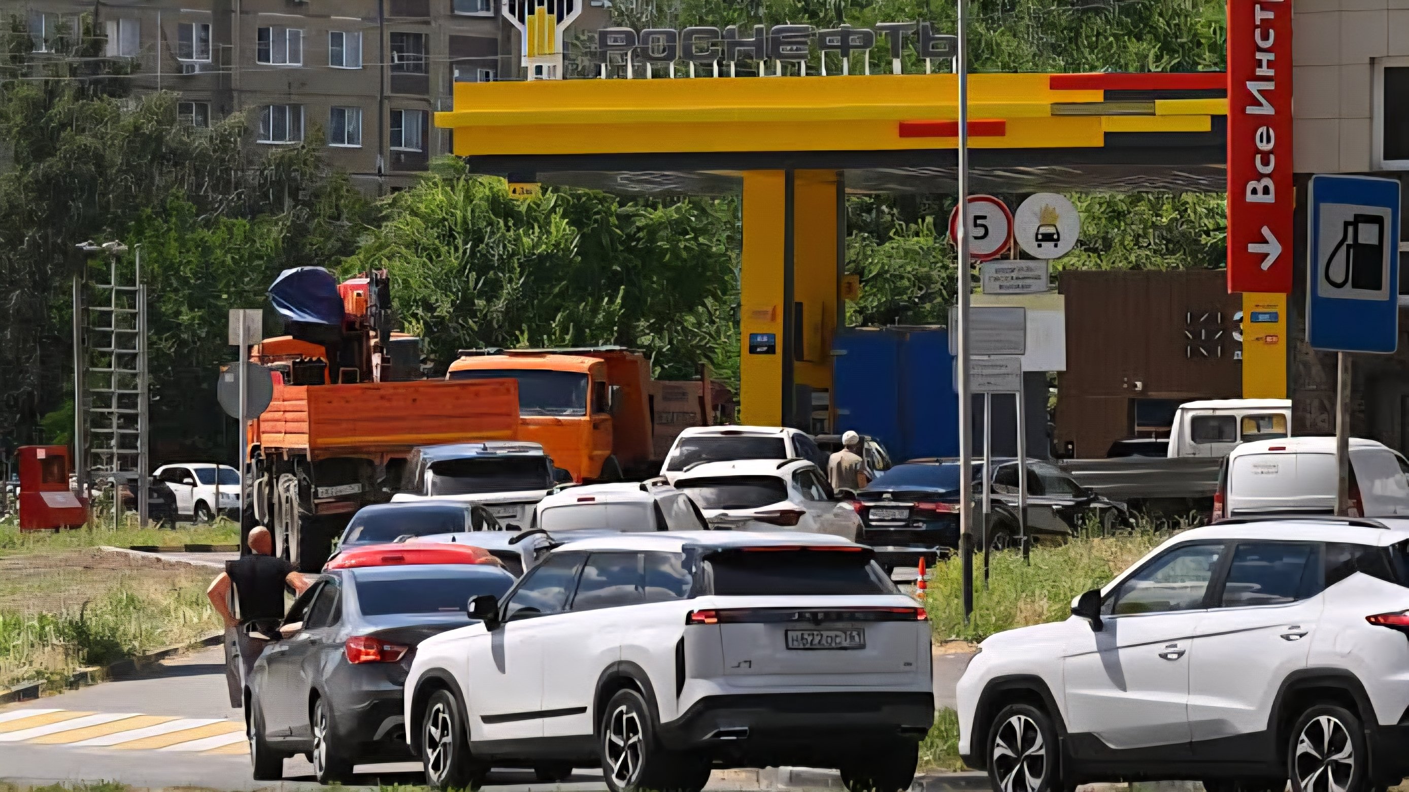 Vehicles lined up at a fuel station in Russia amid shortages, with motorists waiting to refuel.