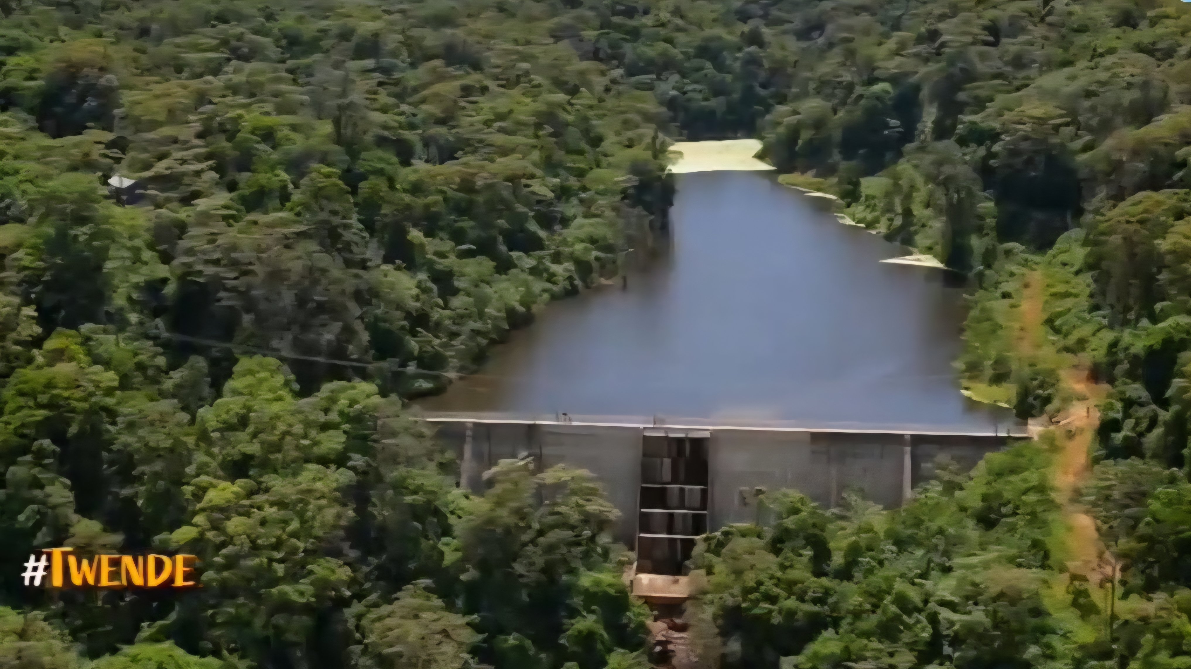 Aerial view of the concrete Bakuli Dam nestled inside the lush green forest canopy of Mount Marsabit.
