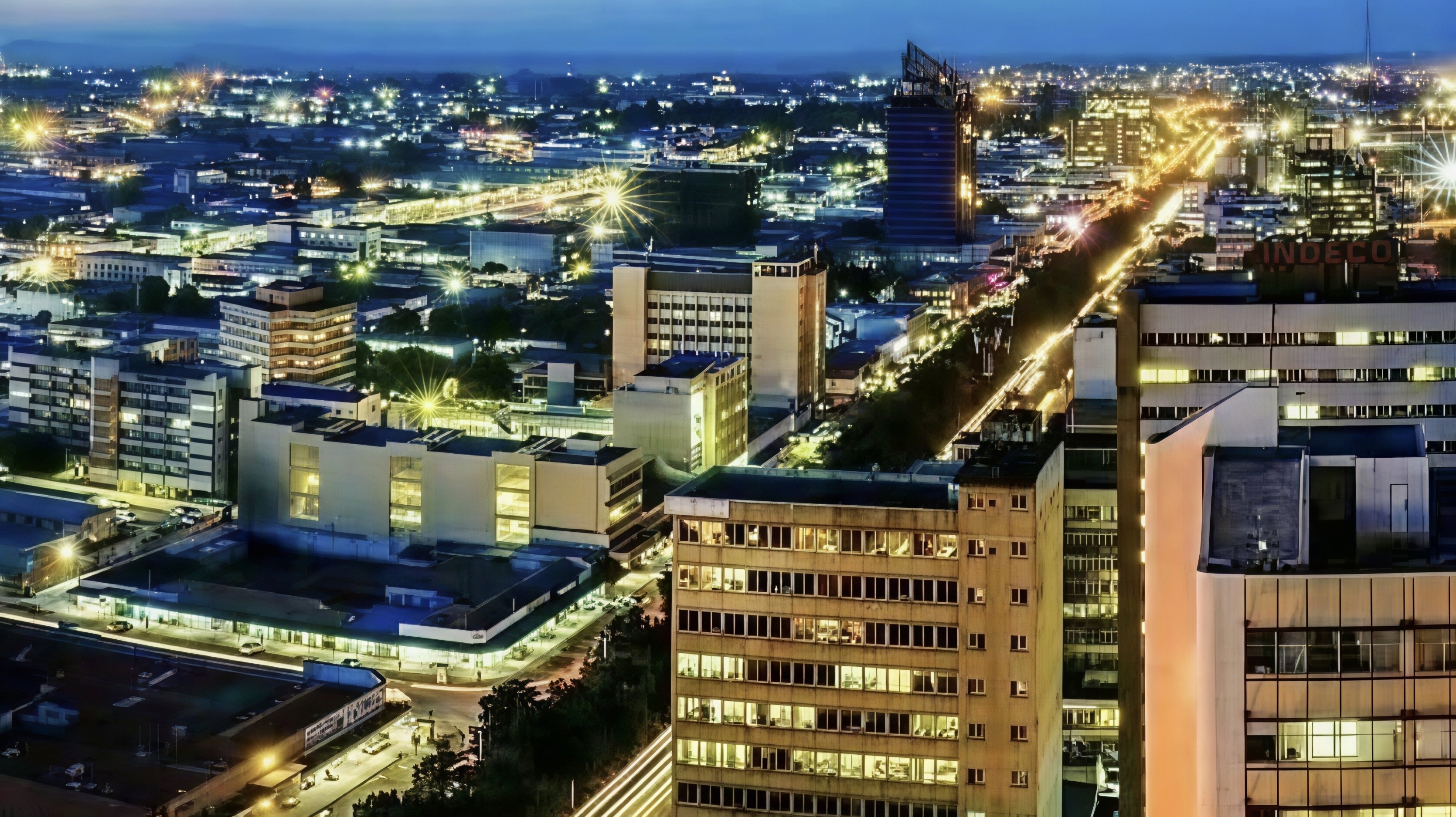 Aerial view of Lusaka city centre, Zambia, showing commercial buildings and urban road infrastructure.