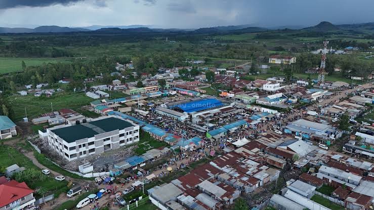 Aerial view of rural market buildings and surrounding agricultural landscape showing trade activity and infrastructure supporting local economic development.