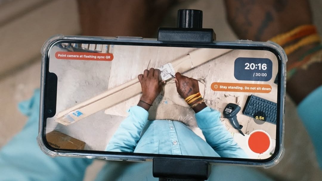 Indian factory workers wearing head-mounted cameras while recording their movements for AI robot training