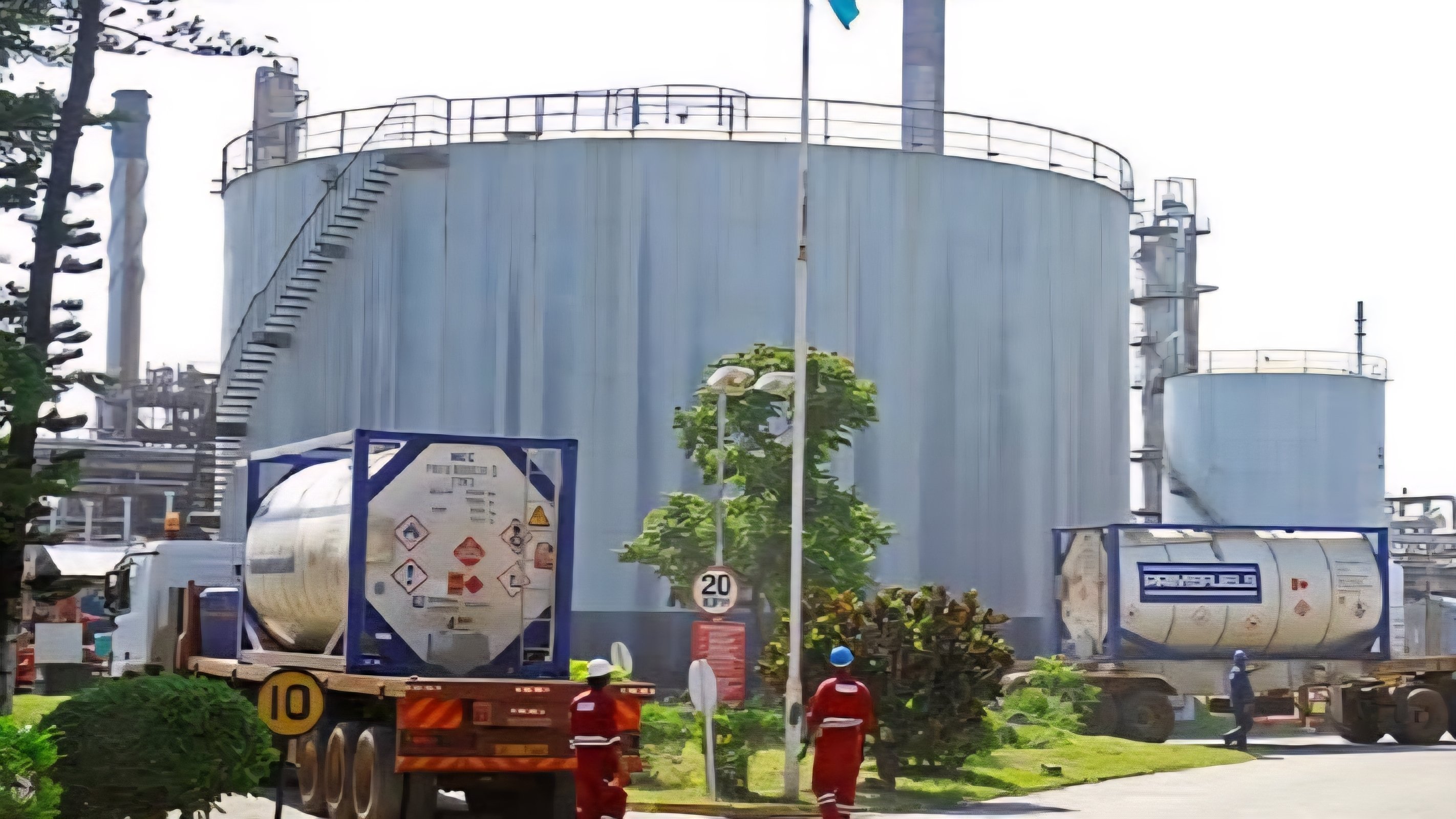 A commercial fuel tanker offloading petroleum products at a terminal in Mombasa, showing industrial storage tanks and logistics infrastructure in the background.