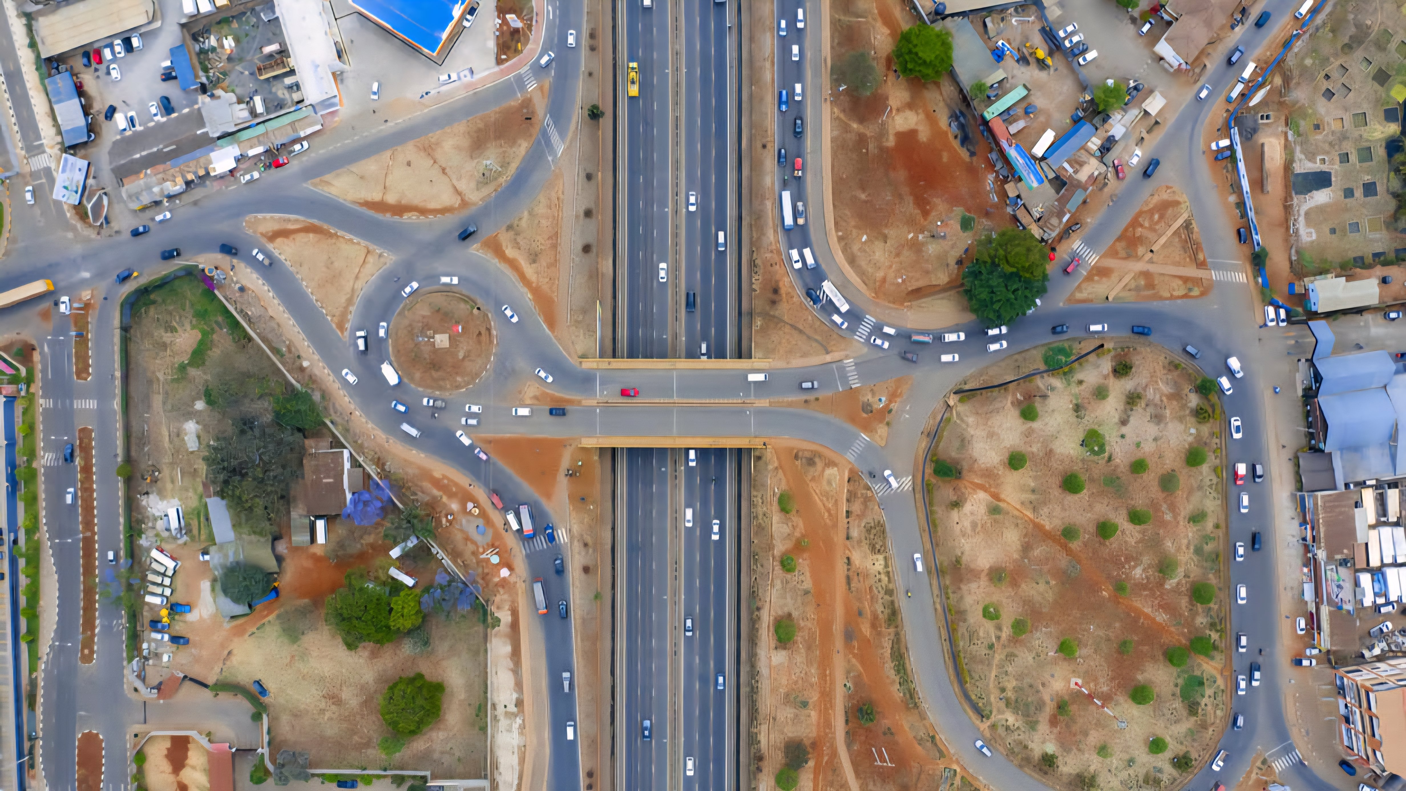A high-angle view of a multi-lane highway in Nairobi, Kenya, showing steady vehicle traffic and overhead digital signage gantries used for traffic management.