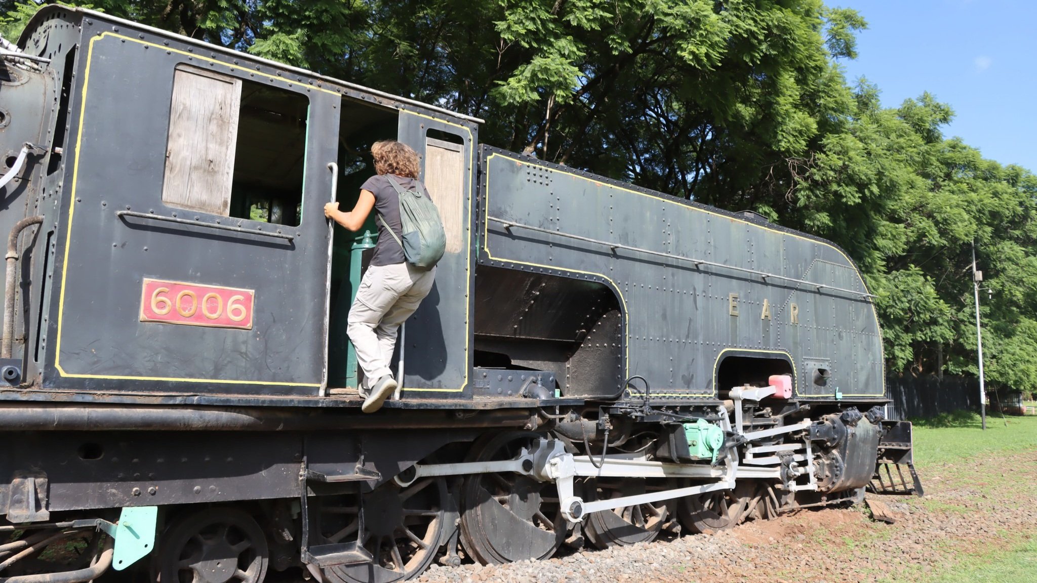 An outdoor display of vintage steam locomotives and railway carriages at the Nairobi Railway Museum.