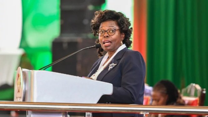 Controller of Budget Margaret Nyakang'o speaking from a podium at a formal government function in Kenya.