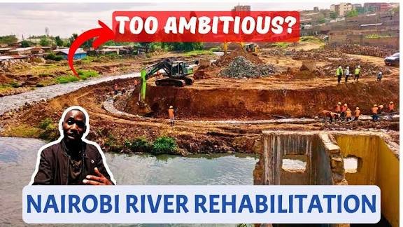 A wide view of a section of the Nairobi River undergoing bank stabilization and cleanup with urban buildings in the background