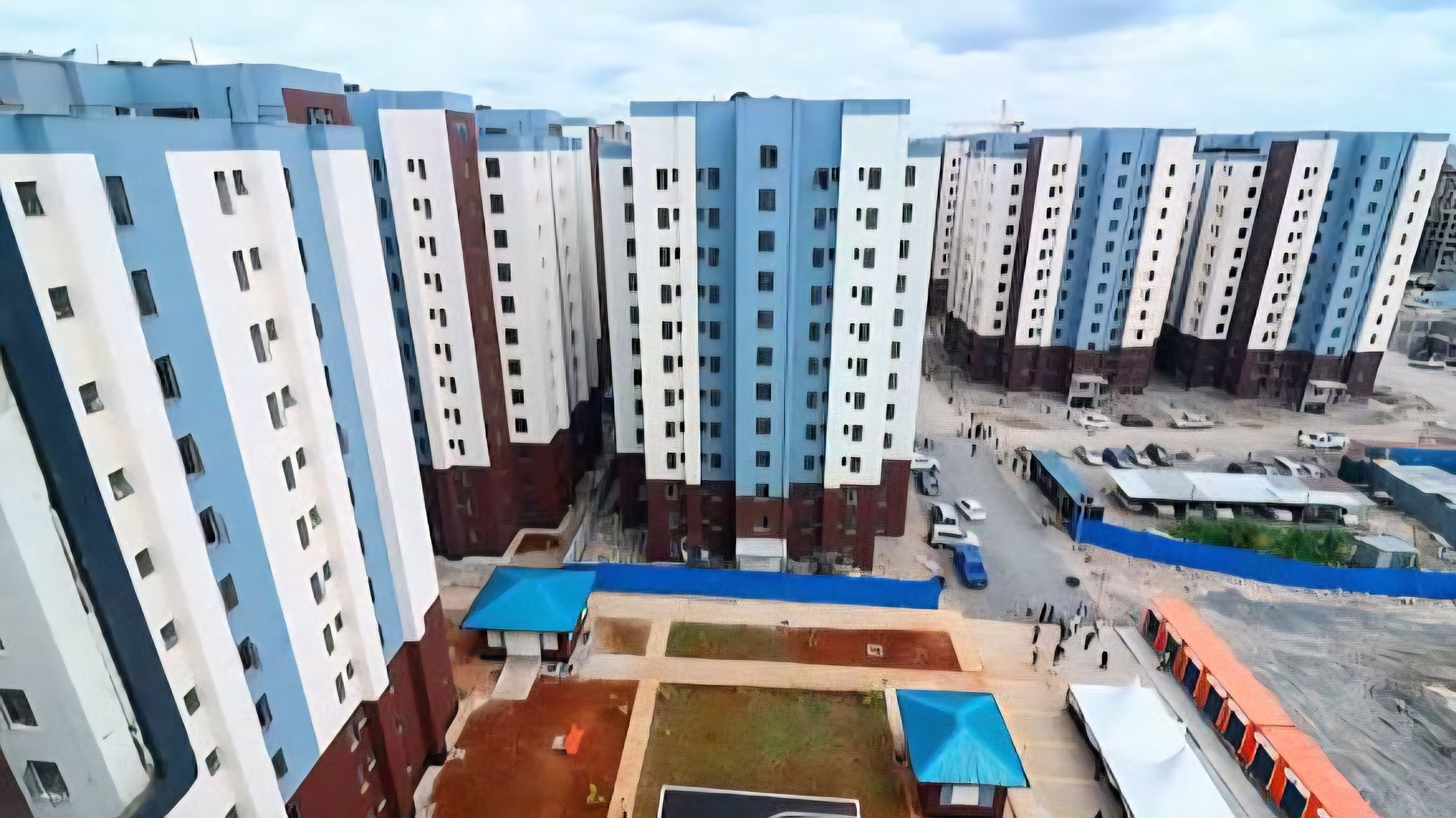 Aerial view of several multi-storey blue and white apartment blocks at the Mukuru Housing Estate in Nairobi.