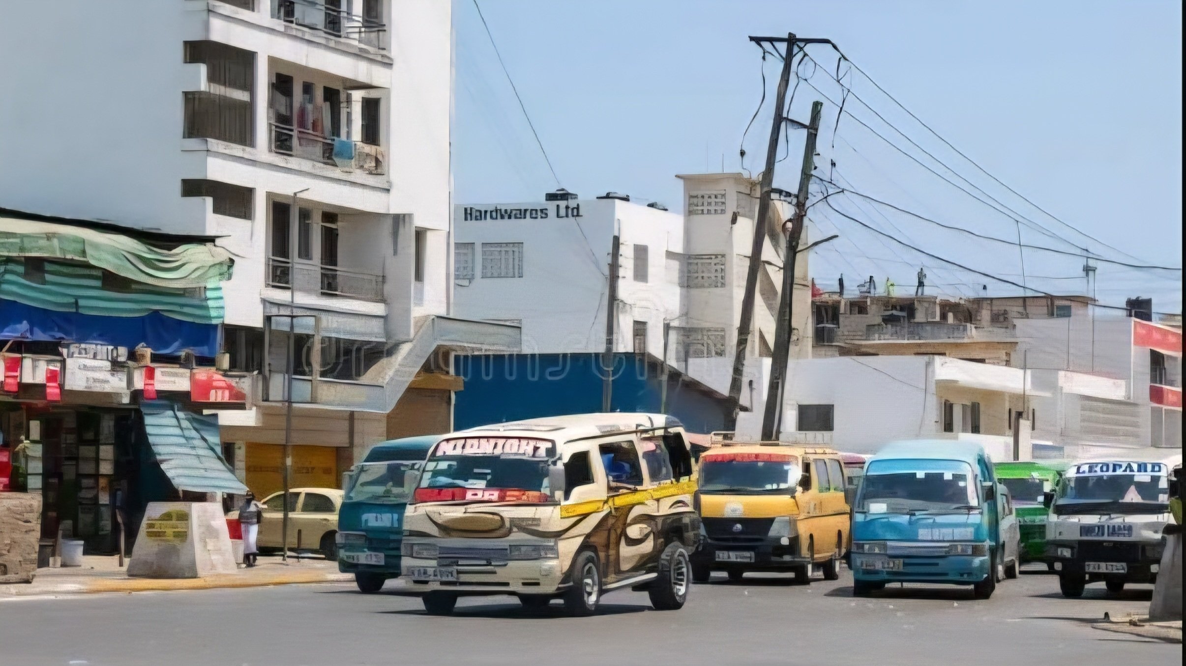 Matatus parked at a bus station in Kenya during a strike announcement, with passengers waiting nearby and transport disrupted.