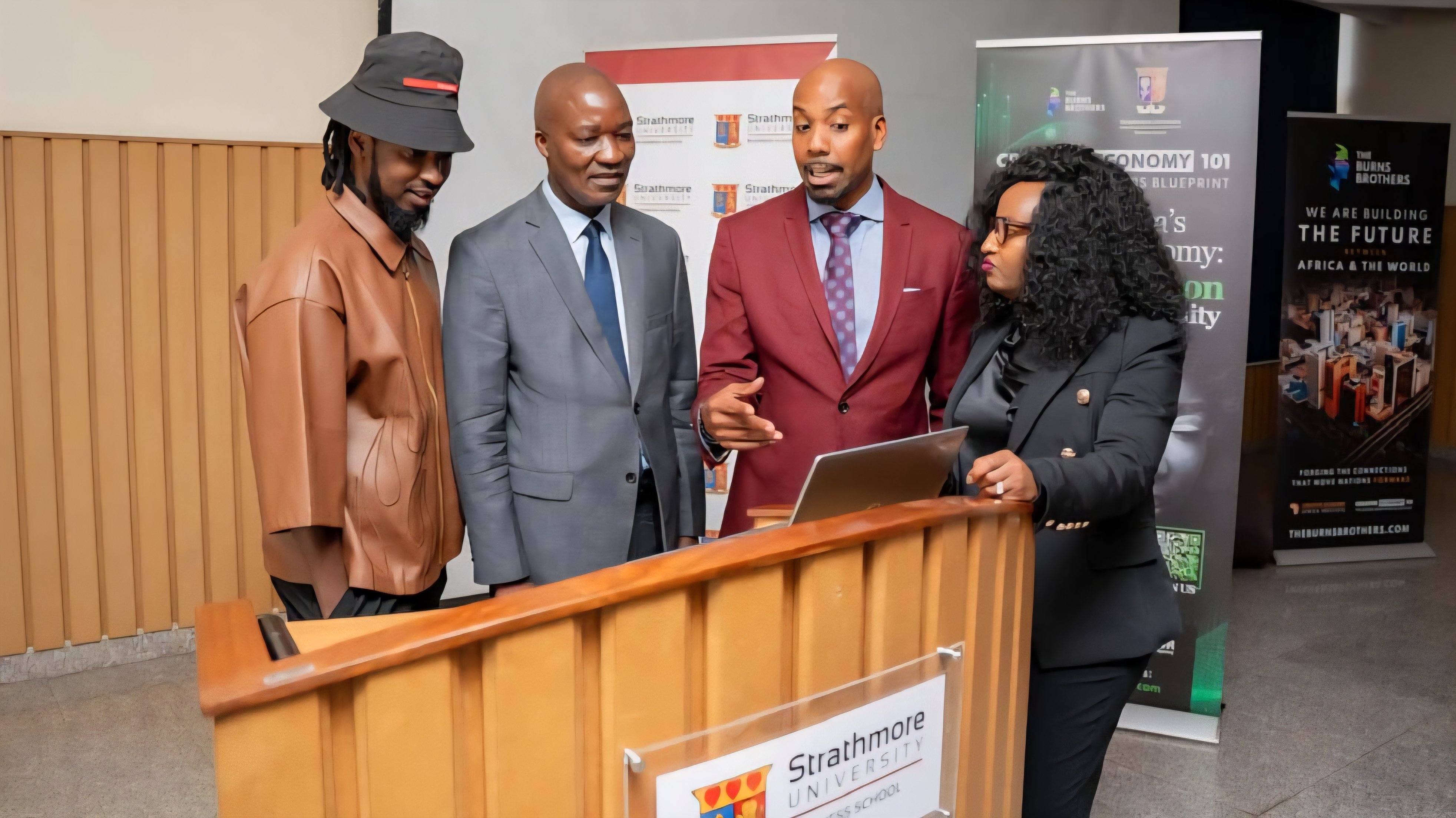 Representatives from Strathmore University Business School and The Burns Brothers gather at a podium during the Creative Economy 101 program launch.