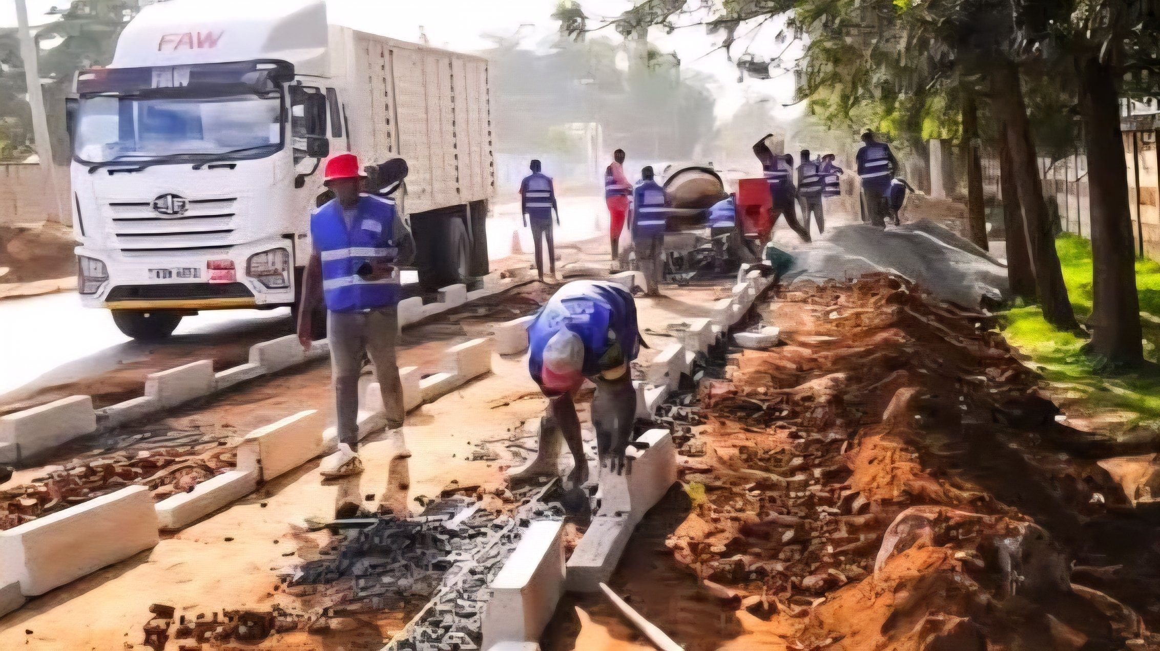 Construction workers laying concrete kerbstones for pedestrian footpaths beside a truck on Kasarani-Roysambu-Mwiki road.