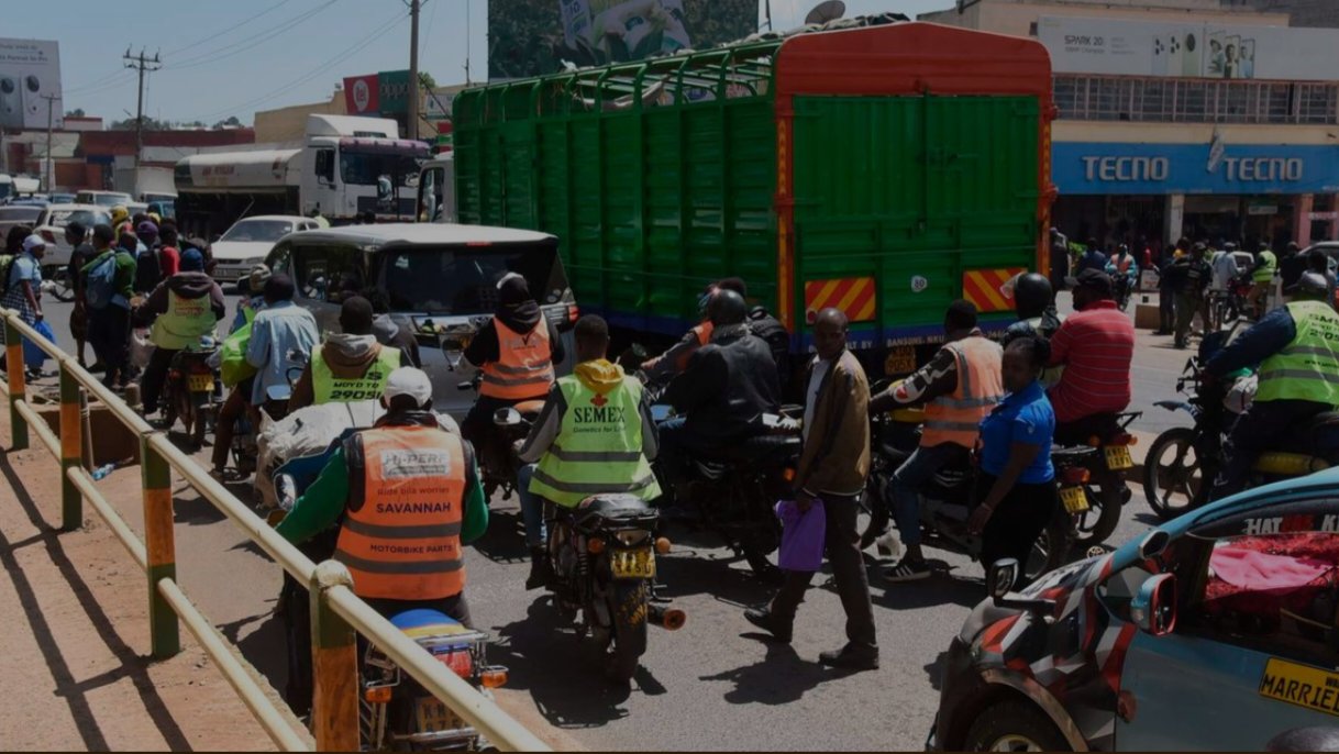 Motorcycles and commercial vehicles operate along a busy street in Eldoret, Uasin Gishu County.
