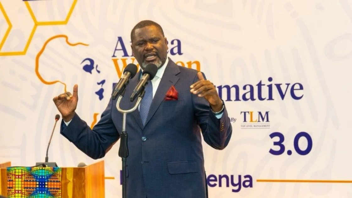 Public Service Cabinet Secretary Geoffrey Ruku speaking at a podium during the Africa Women Transformative Summit 3.0 in Nairobi.