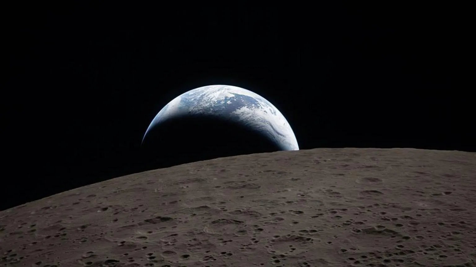 A view of the Earth rising over the dark, cratered horizon of the lunar surface.