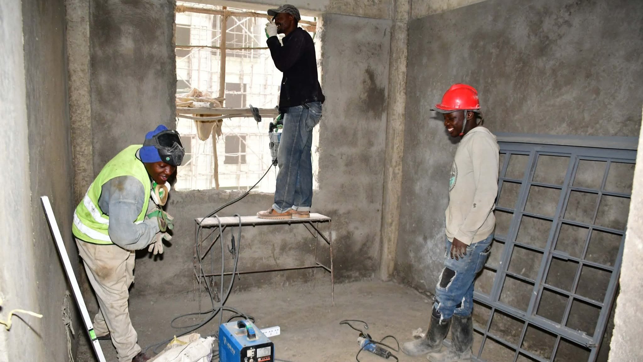 Construction workers applying plaster to exterior walls at the Limuru Affordable Housing Project site in Kiambu County, Kenya